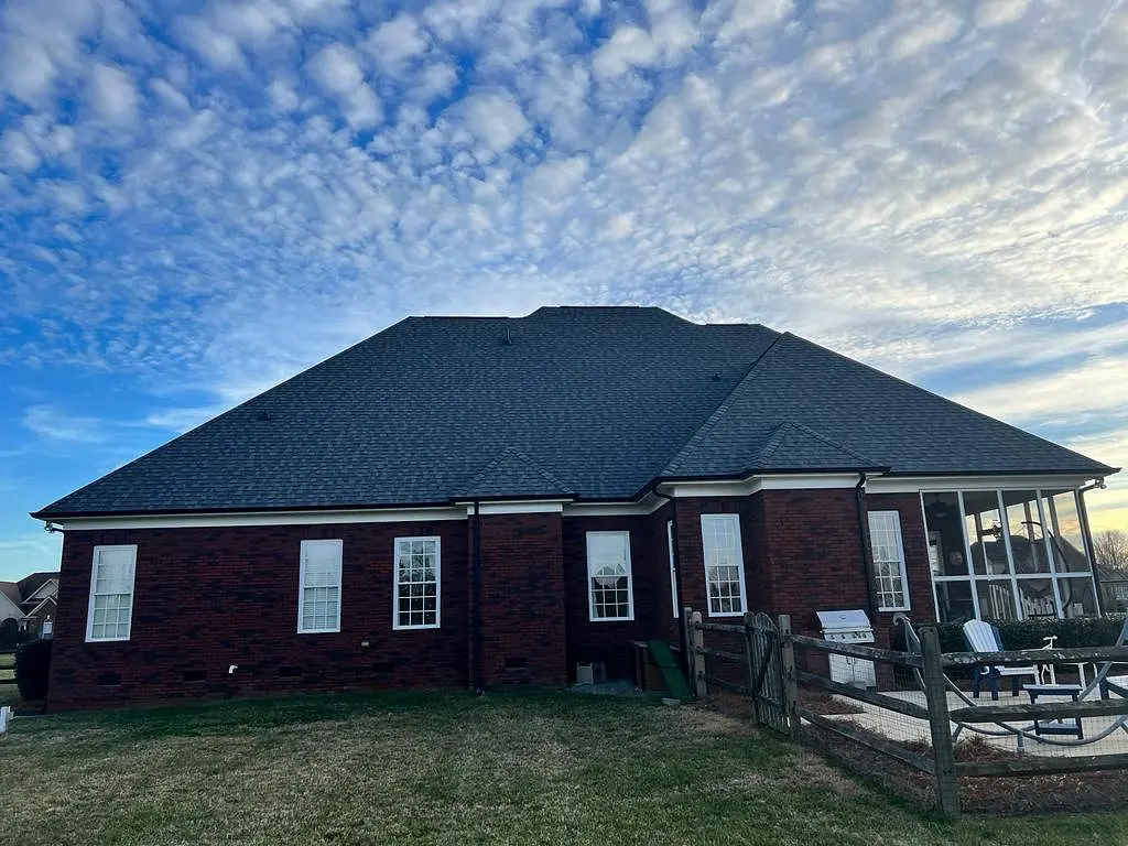 Rear of a brick ranch home with a new roof