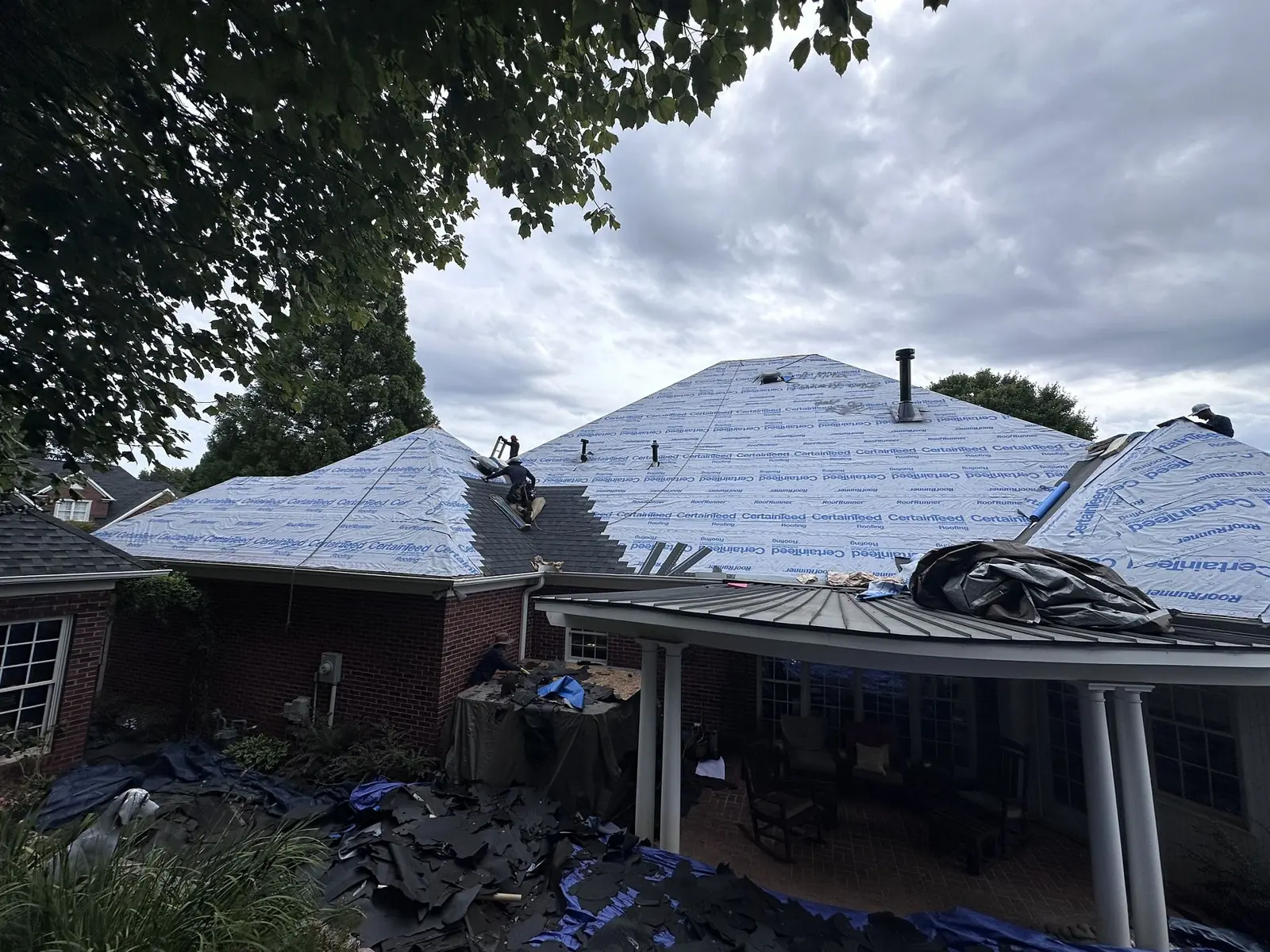 Crew installing synthetic underlayment during a re-roof