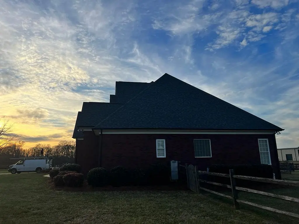 Finished roof at sunset with the work van parked nearby